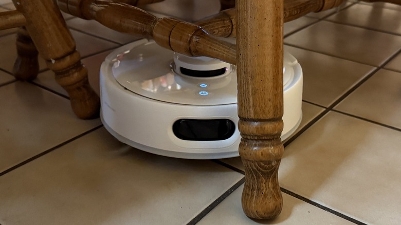 Switchbot robot vacuum maneuvering between chairs