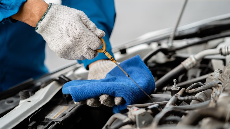 Technician checks oil dipstick