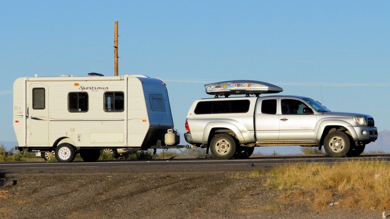 Silver Toyota Tundra hauling a camper and kayak