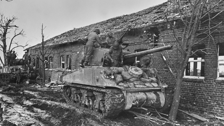 Sherman tanks against a building