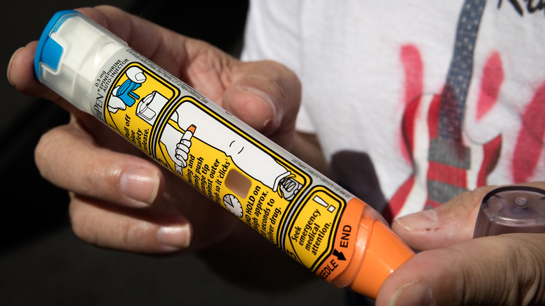 person holding epipen