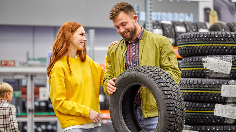 woman and man looking at a tire