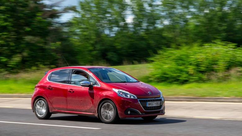 A first generation Peugeot 208 on the move, front 3/4 view