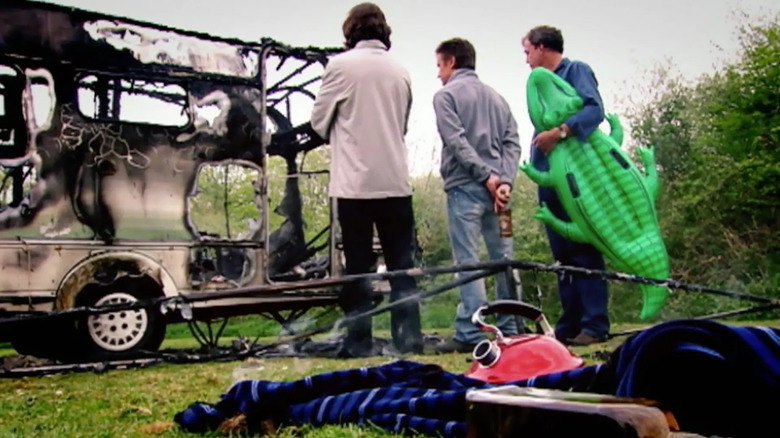 Presenters looking at burnt up caravan