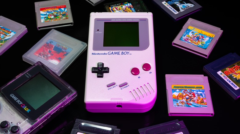 A Game Boy and Game Boy Color with games strewn about