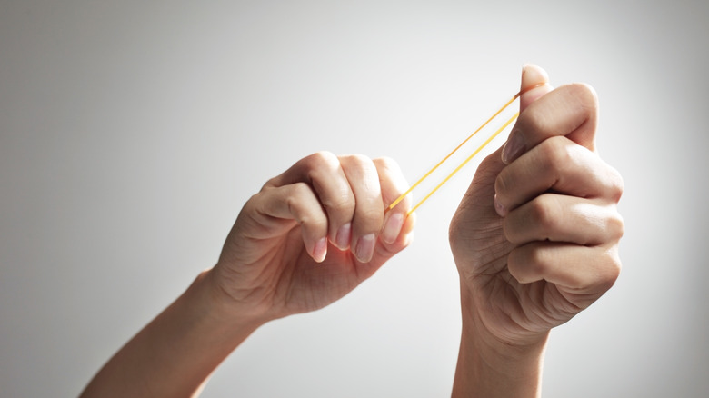 Hands stretching a rubber band