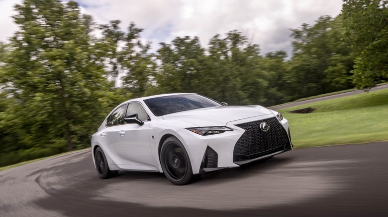 White 2024 Lexus IS 350 cornering on a twisty road