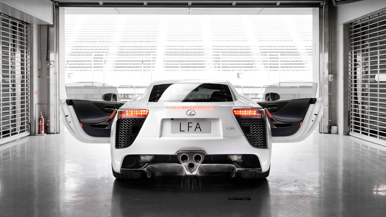 White Lexus LFA with opened doors photographed from the rear in a track garage