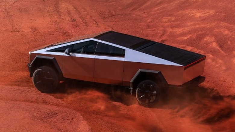 A silver Tesla Cybertruck in red sand