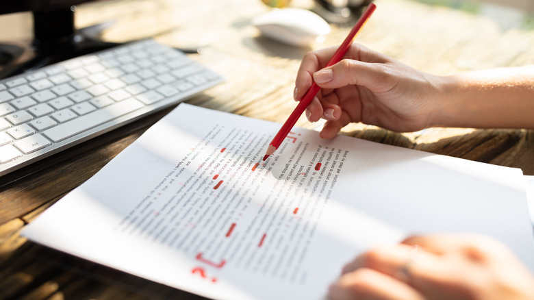 woman's hands editing document with red pen