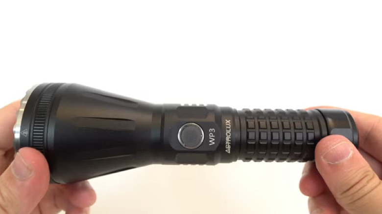 Astrolux flashlight between fingers