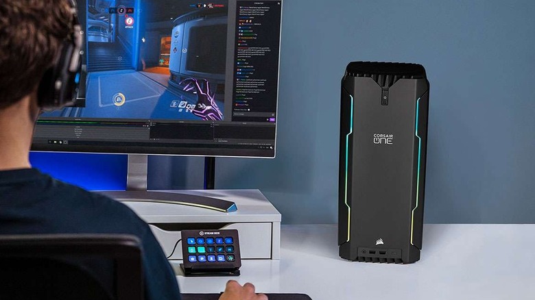 Corsair One a200 sitting on a desk next to a monitor, with a guy playing a game