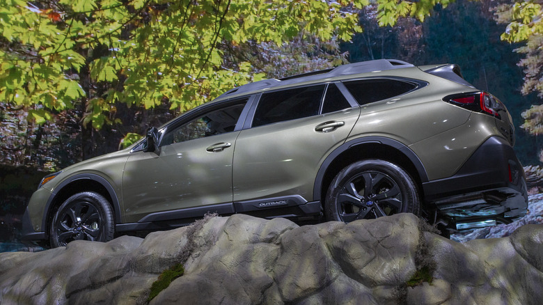 Subaru Outback on top of a forest scene