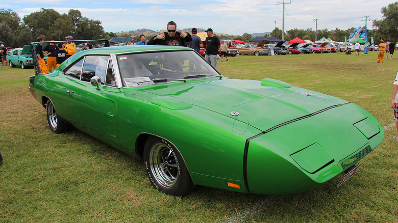 A green Dodge Charger Daytona parked in the grass