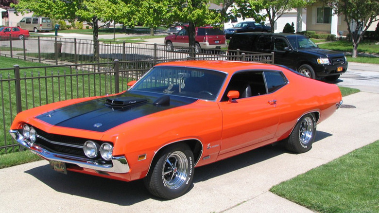 An orange and black 1970 Ford Torino in a driveway