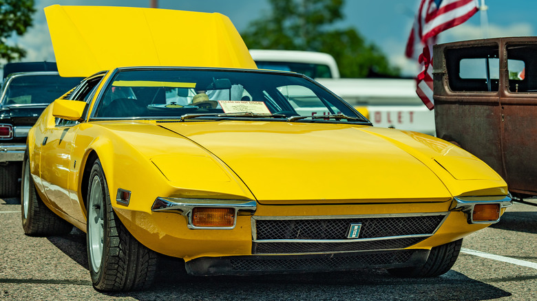 A yellow De Tomaso Pantera in a parking space