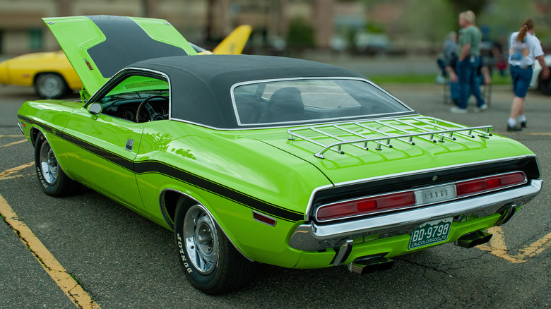 A green Dodge Challenger R/T in a parking spot