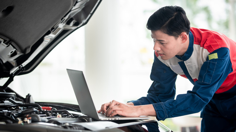 Man checks laptop engine