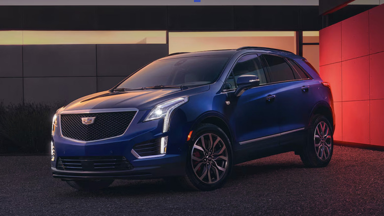 A blue Cadillac XT5 in a fancy garage at sunset