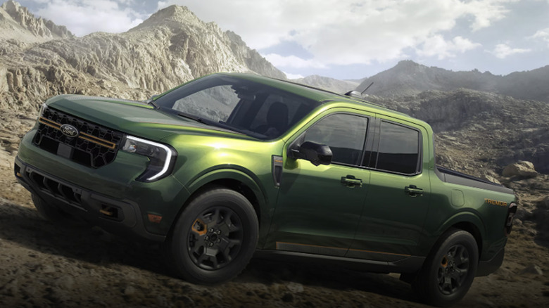 A green Ford Maverick parked in a mountainous area