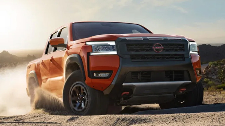 A red Nissan Frontier driving off road