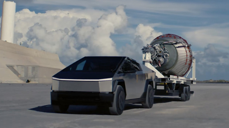 A Tesla Cybertruck towing a piece of a SpaceX rocket