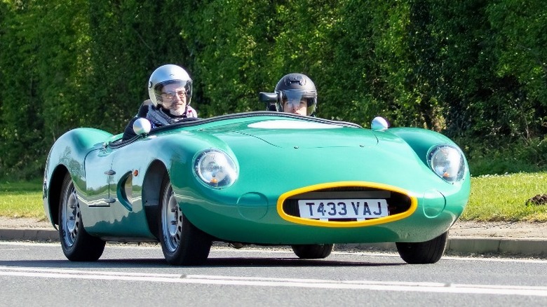 green Aston Martin DBR1 with driver and passenger