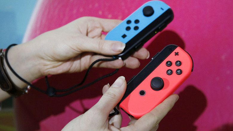 Person holding two Joy-Cons