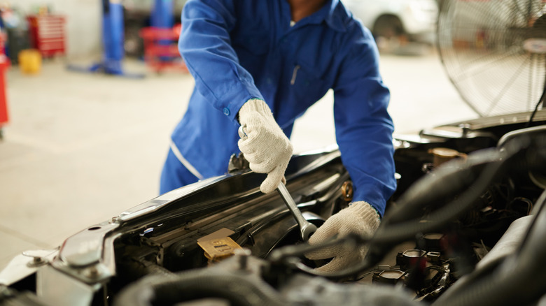 Professional mechanic fixing vehicle transmission