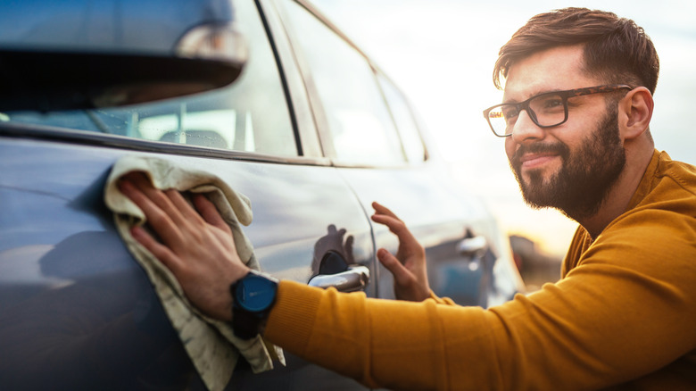 Person wiping wax off of car