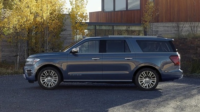 Ford Expedition Platinum MAX parked outside with a brown building and trees in the background