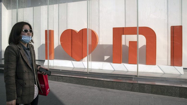 Woman walking by Xiaomi sign 