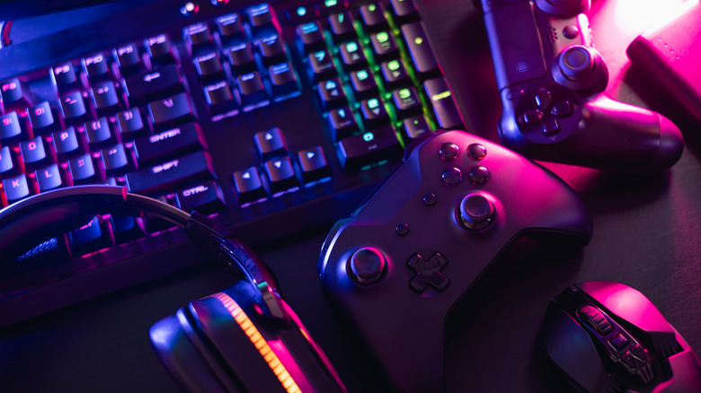 PS4 and Xbox One controllers next to a keyboard, mouse and headphones.