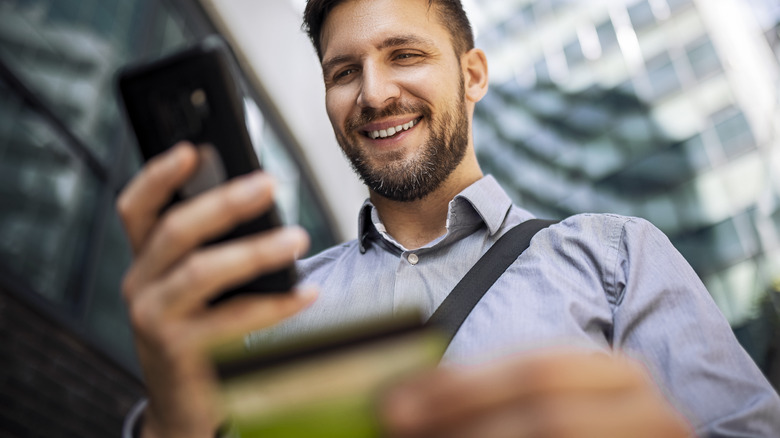 person holding phone and card