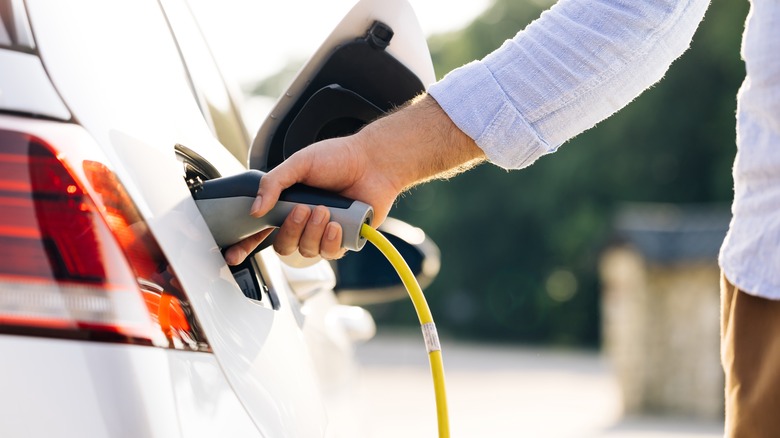 person plugging in EV charger