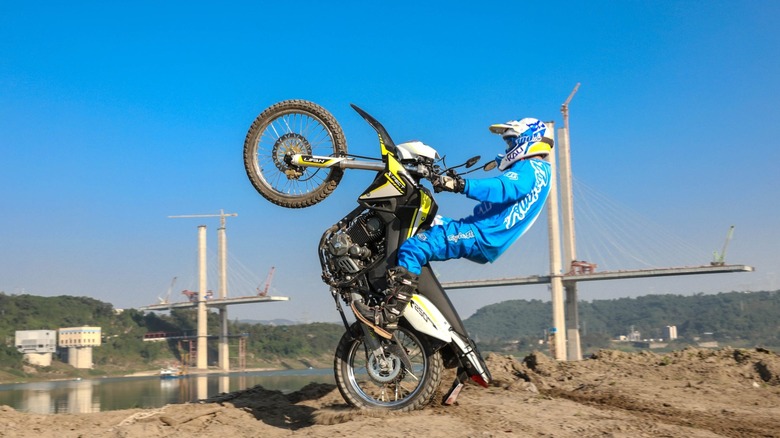 Lifan KPX 250 rider doing a wheelie on top of a hill