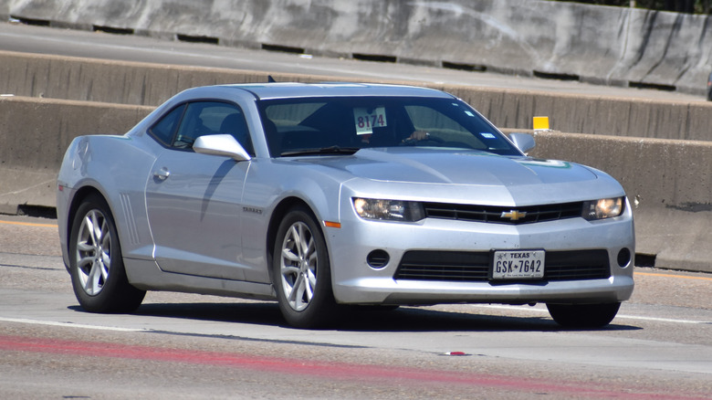 Silver Camaro riding down the street