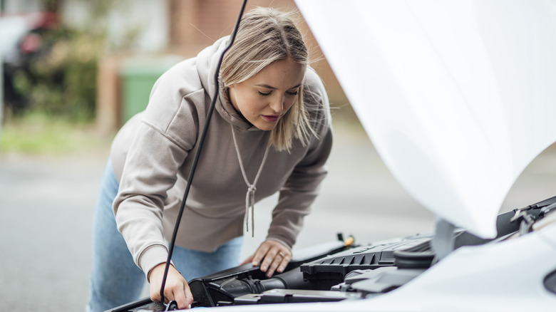 woman looking under the hood