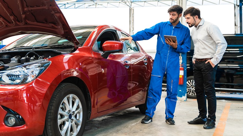 mechanic showing driver red car