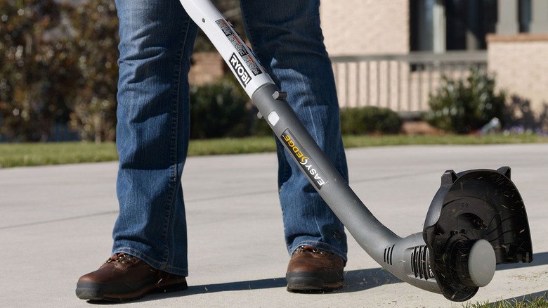 person using ryobi string trimmer