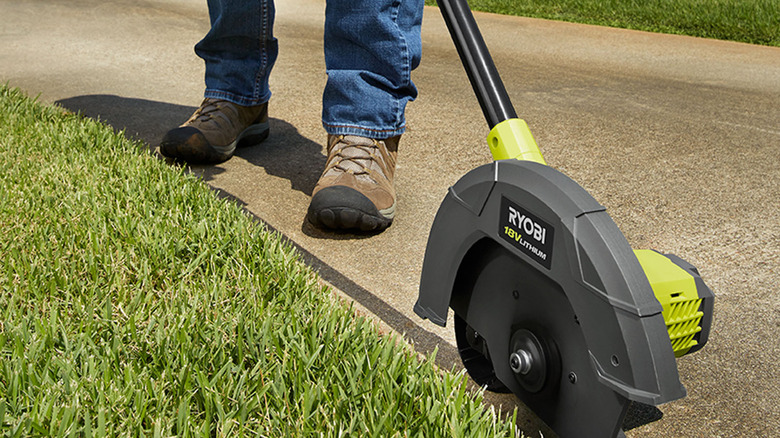 person using ryobi edger