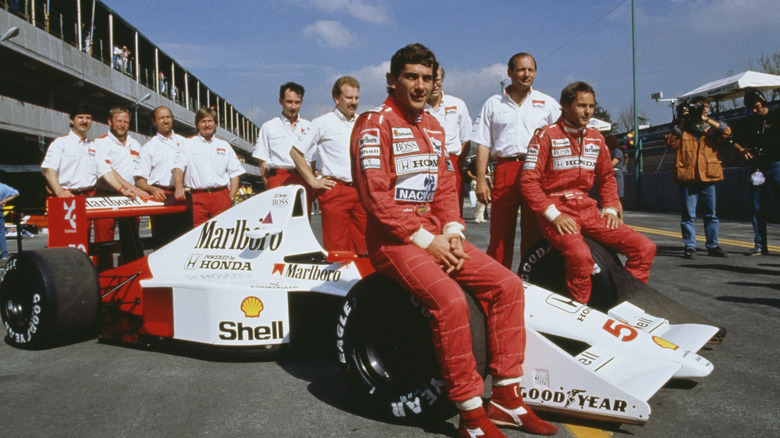 Ayrton Senna posing on car