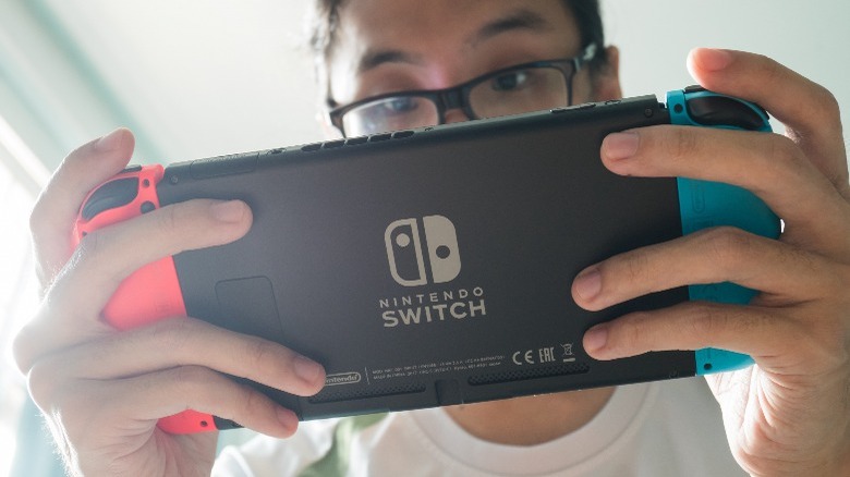 A person holding their Switch