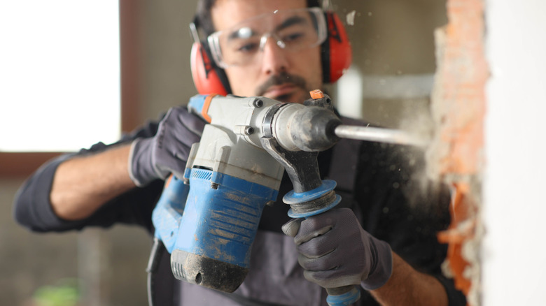 Rotary hammer removing brick and mortar