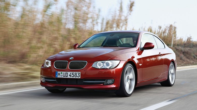 2011 BMW 3 Series Coupe driving at speed front 3/4 view