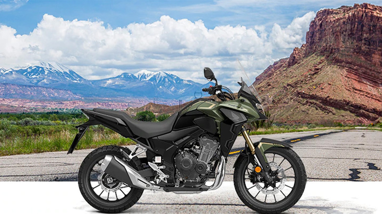 A green Honda motorcycle against a landscape background