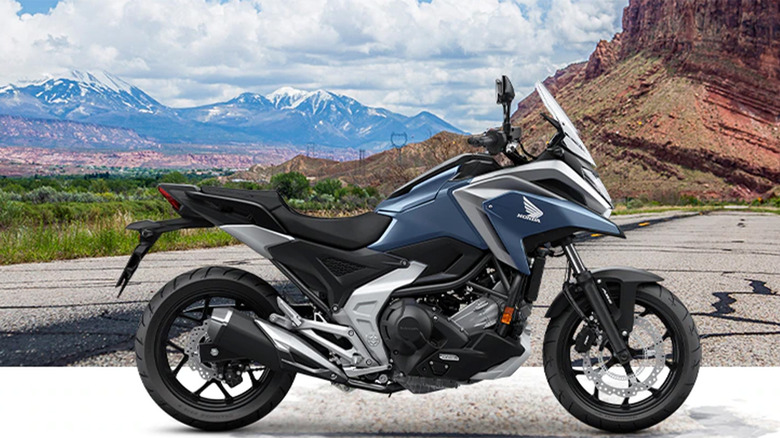 A blue Honda motorcycle with mountains in the background