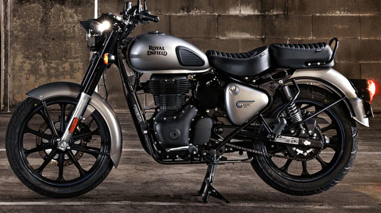 A silver Royal Enfield motorcycle against a concrete background