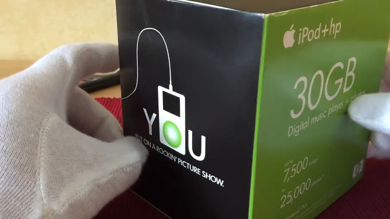 Hands in white gloves hold an Apple iPod+HP box in an unboxing video