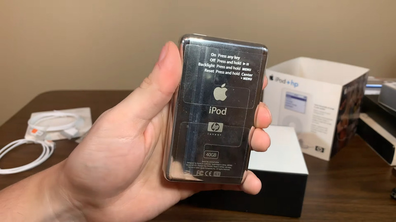 A hand holds an Apple iPod+HP at its unboxing